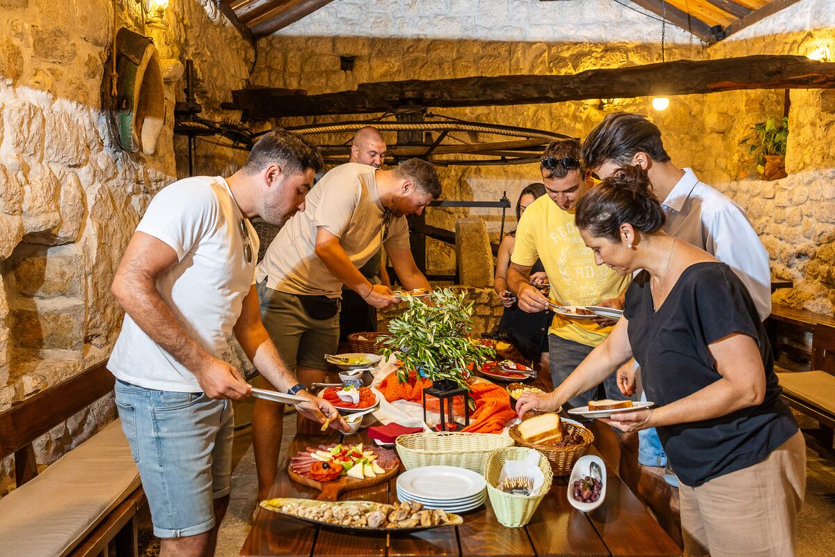 Gosti se poslužuju domaćim delicijama za drvenim stolom