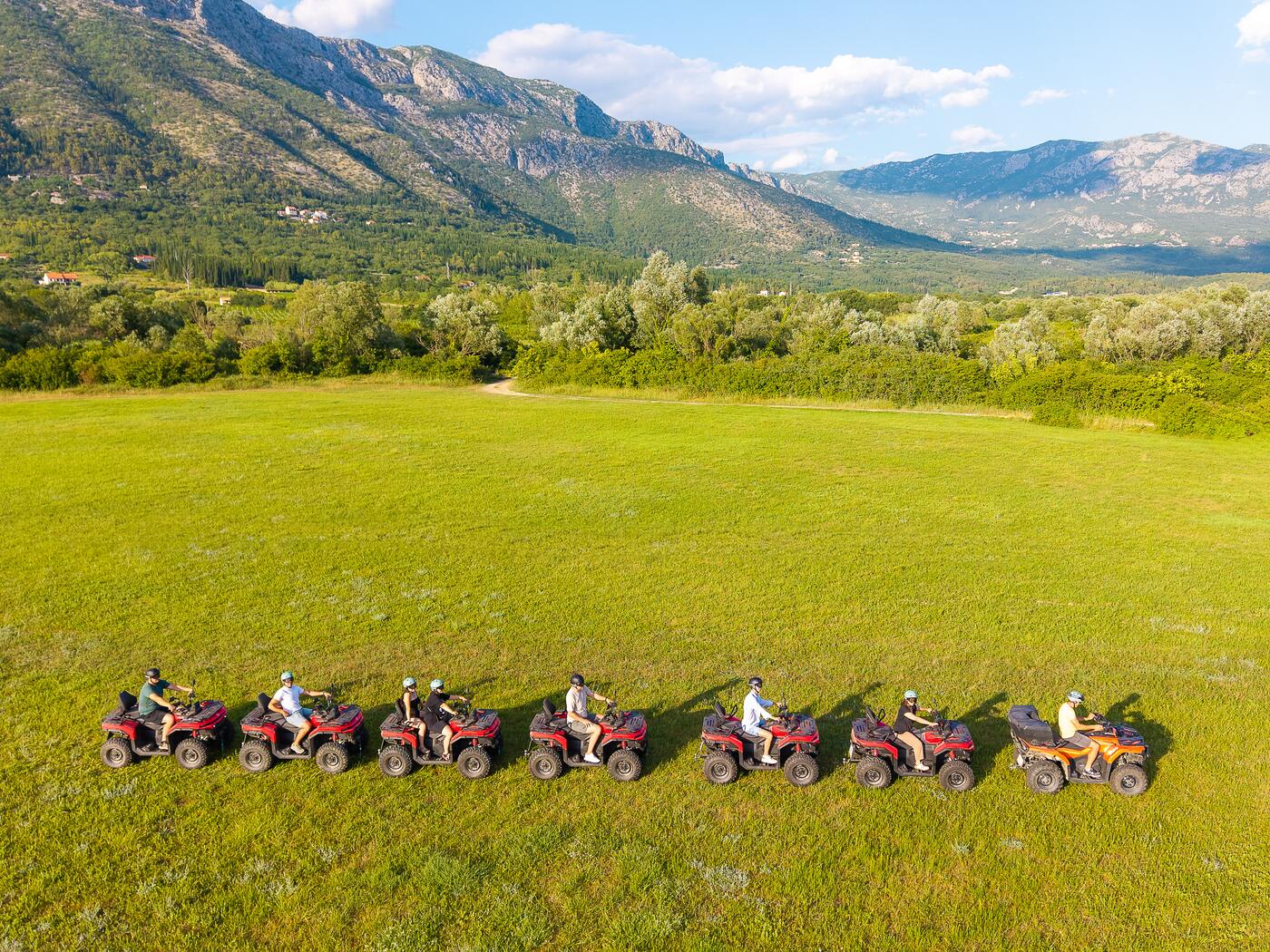 Red potpuno novih CF Moto quadova na livadi ispod planine