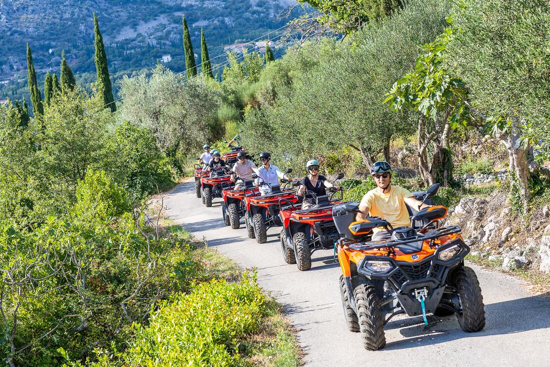 Eine Quad-Kolonne auf einem von Zypressen gesäumten Weg